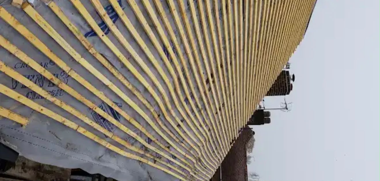 Vertical treated timber battens laid over grey roofing underlay