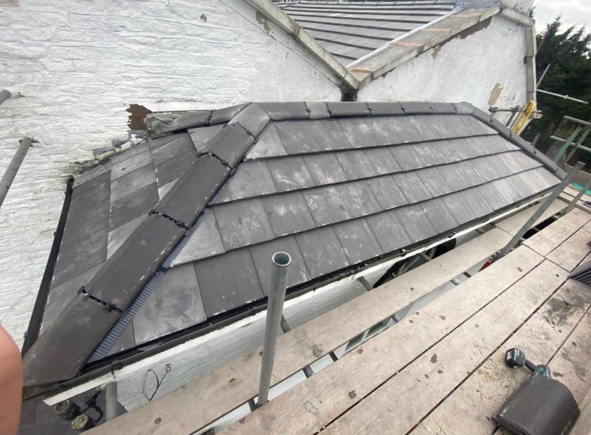 Finished slate roof section with grey dry-ridge tiles